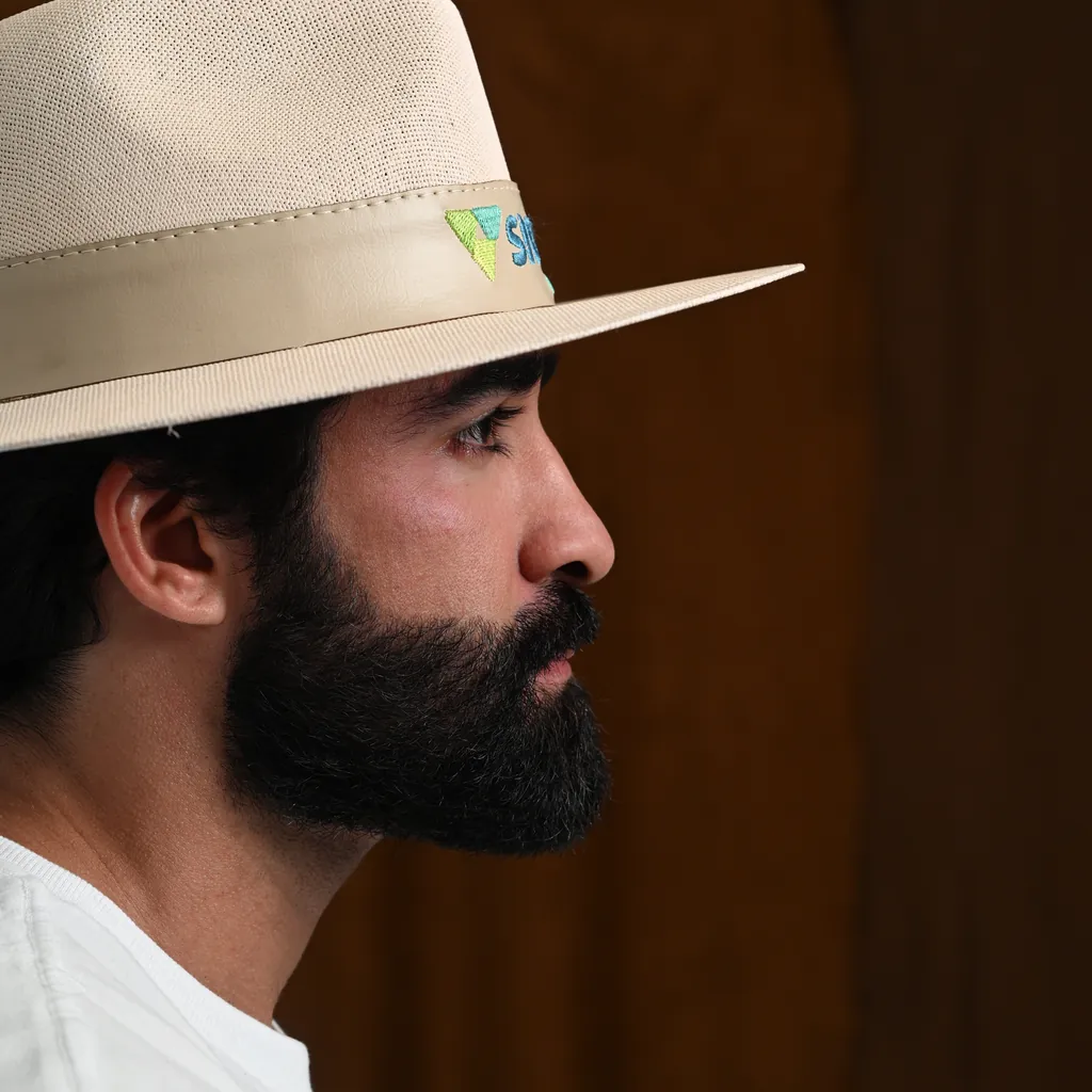 Homem usando chapéu personalizado bege com logo na fita
