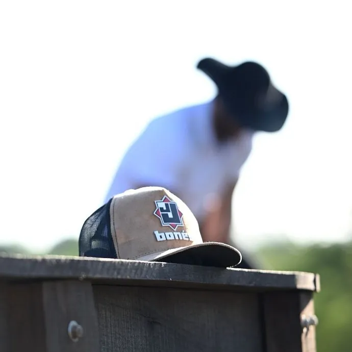 Boné de camurça personalizado apoiado em porteira de fazenda